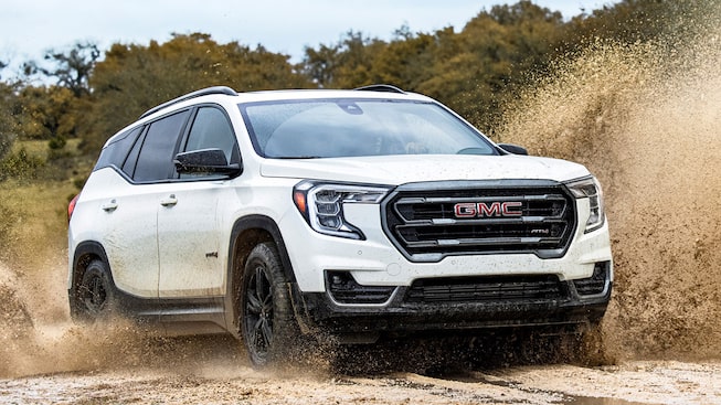 The Stylish Summit White GMC Terrain AT4 Driving Off-Road through Mud and Water