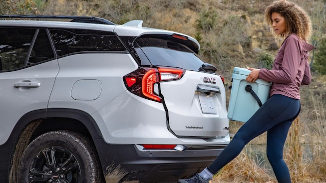 Women Holding Container Waving Her Foot under Trunk for Hands-Free Assistance on the GMC Terrain AT4