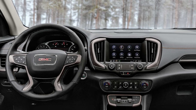 Steering Wheel, Infotainment System, and Heads-Up Display of the GMC Terrain AT4 Parked by Trees