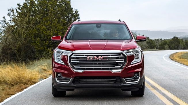 Red GMC Terrain SLT Driving On-Road With Grass and Trees Head-On