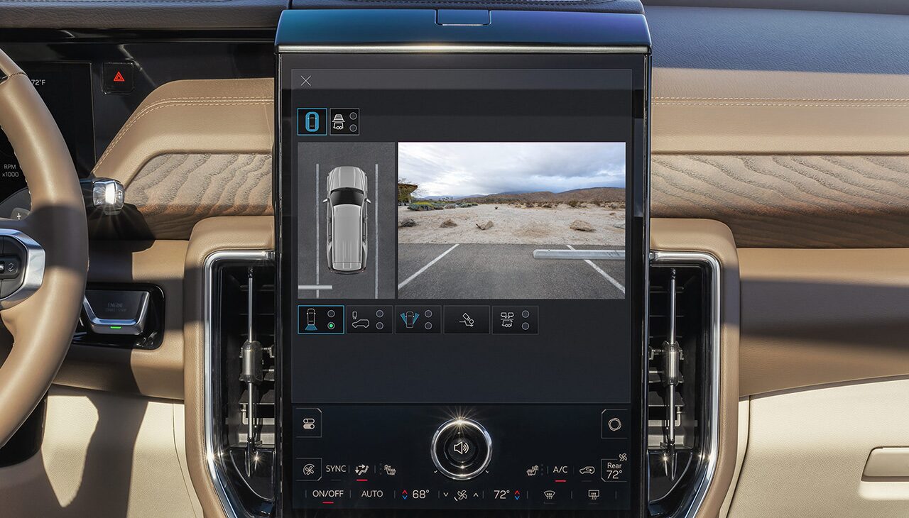 Vertical GMC Infotainment Screen Displaying HD Surround Vision with an Overhead View of a Truck and a Desert Parking Lot
