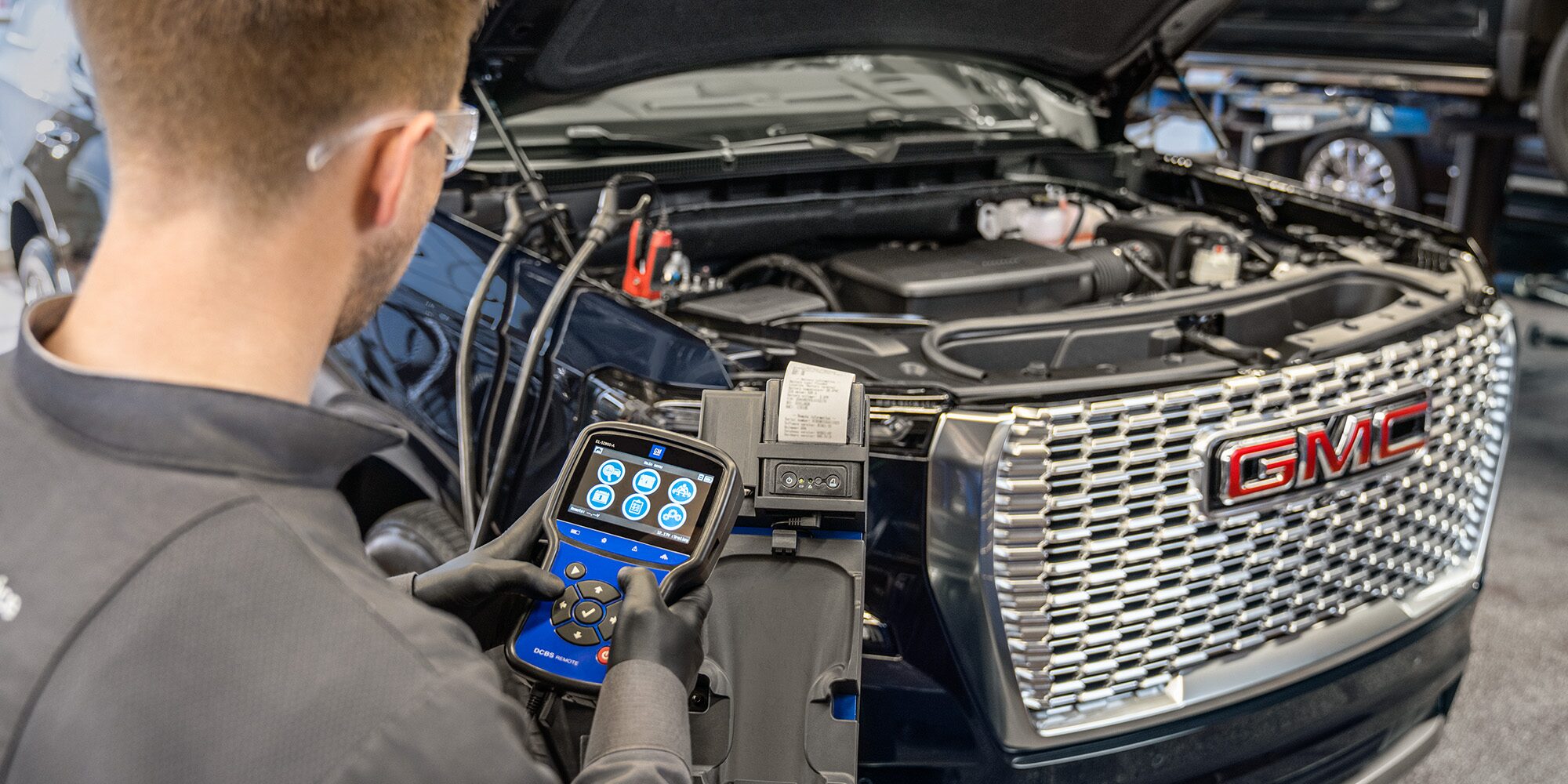 GMC Certified Service Technician Using a Vehicle Diagnostics Tool on a Vehicle