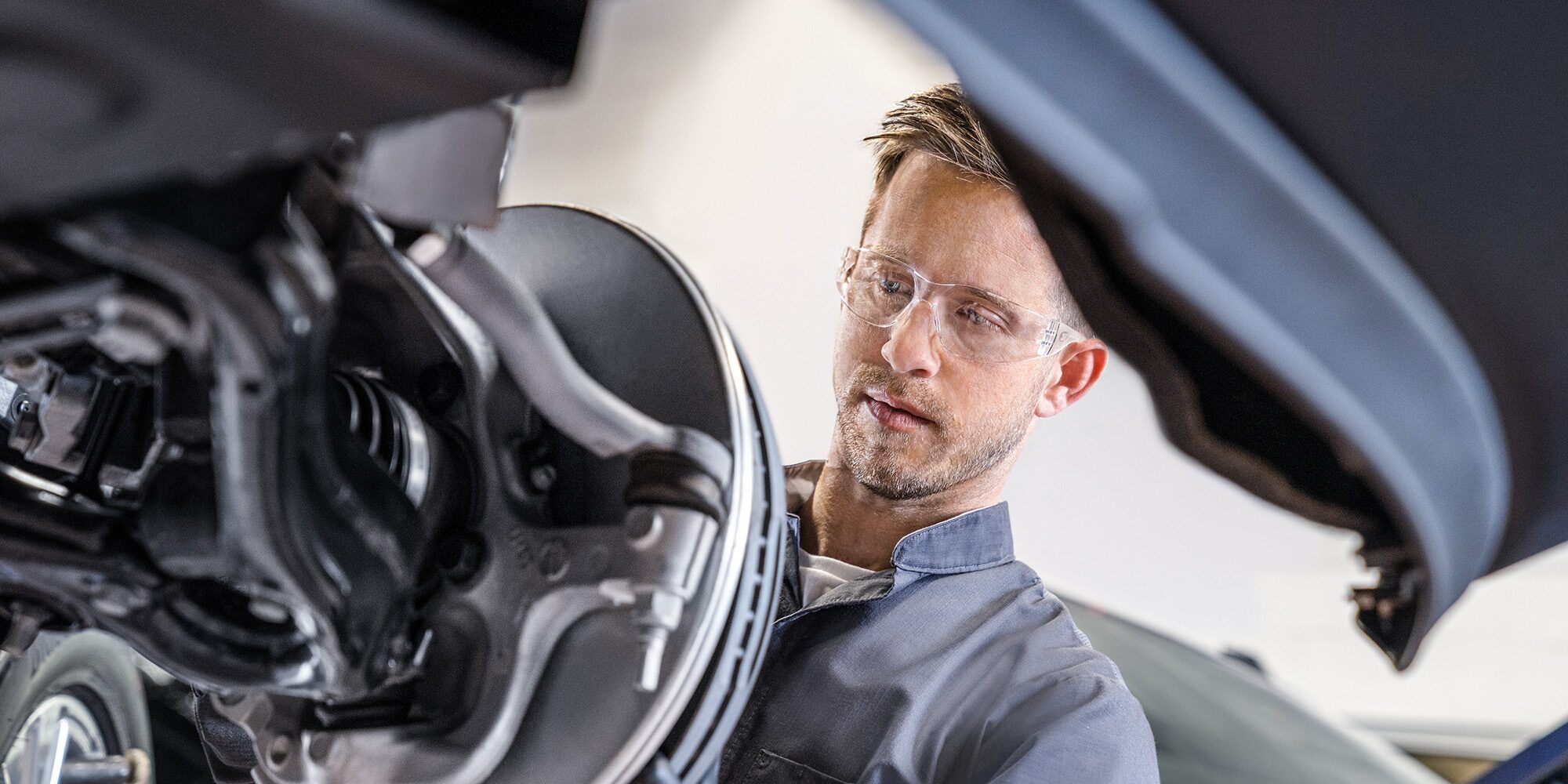 GMC Certified Service Technician Installing a New Brake Rotor on a Vehicle