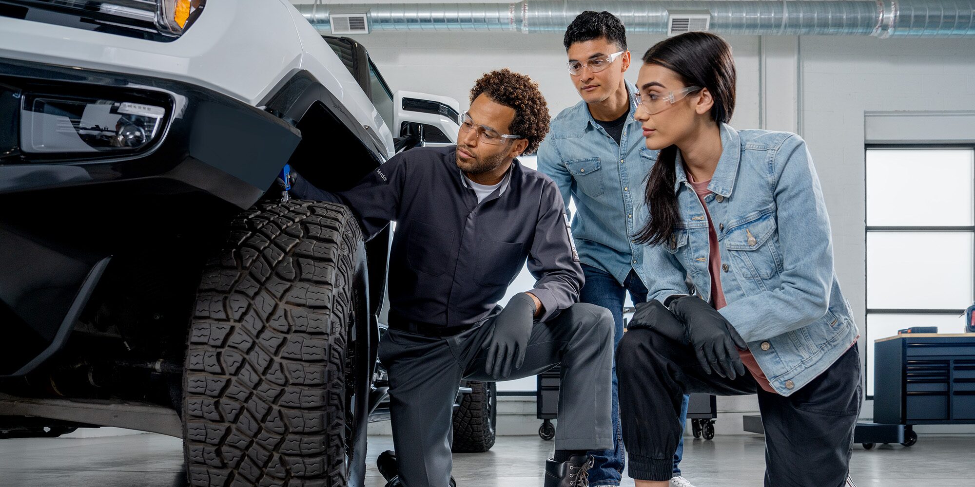 GMC Certified Service Technician Inspecting a Vehicle with Automotive Students