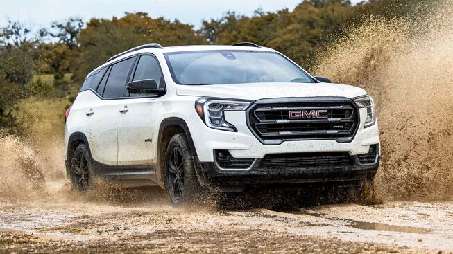 The Stylish Summit White GMC Terrain AT4 Driving Off-Road through Mud and Water