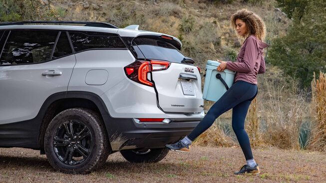 Women Holding Container Waving Her Foot under Trunk for Hands-Free Assistance on the GMC Terrain AT4