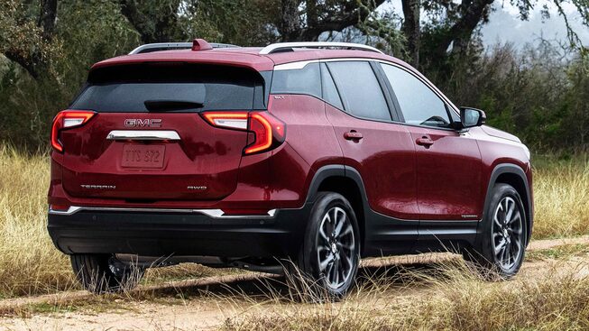 Red GMC Terrain SLT Driving Off-Road With Grass and Trees