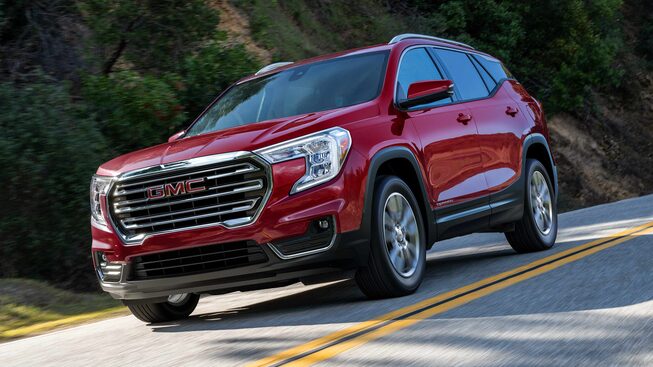 Red GMC Terrain SLT Driving On-Road With Trees and Hills
