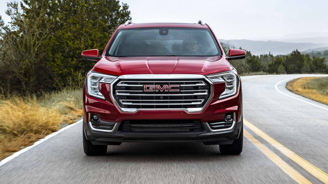 Red GMC Terrain SLT Driving On-Road With Grass and Trees Head-On