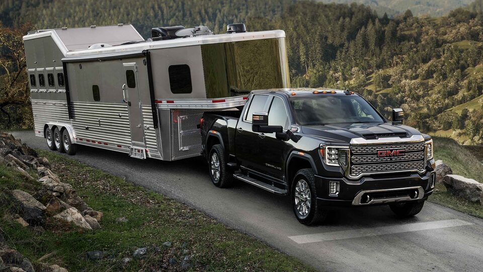 The Sierra HD On an Open Mountain Road Towing a Trailer with Ease