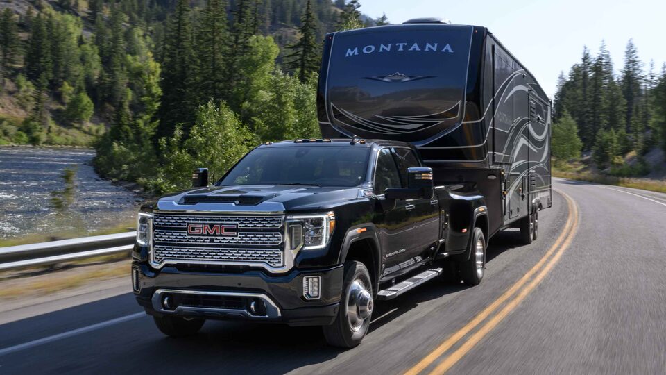 The Sierra HD Towing a RV Through an Open Mountain Road