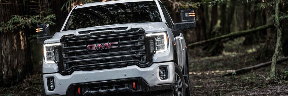 The 2023 Sierra AT4 HD Imposing Grille & Front Design Off-Roading in the Woods