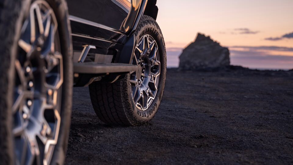 Rear Tire View of a Front Wheel on the 2025 GMC Hummer EV Pickup Truck Overlooking the Sunset