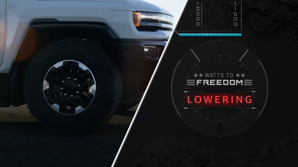 Close-Up of the Wheel and Headlight on a 2025 Hummer EV Truck with Text Overlay "Watts to Freedom Lowering"