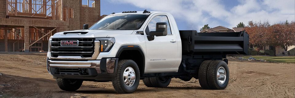 Front Three-Quarters View of a 2025 GMC Sierra HD Chassis Cab Work Truck Parked at a Job Site