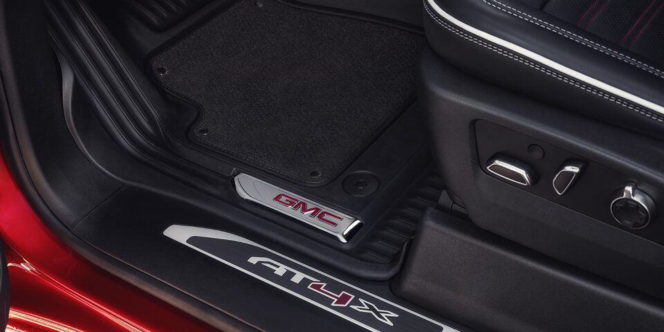 Close-up View of the Seat Controls and "AT4X" Branded Kickplate in a 2025 GMC Sierra HD AT4 Truck