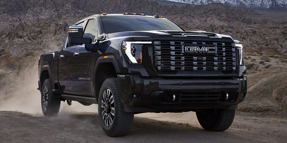Front Three-Quarters View of a 2025 GMC Sierra HD Denali Truck Driving Through the Desert