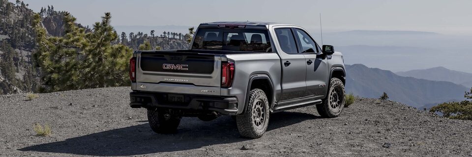 Rear View of the 2025 GMC Sierra AT4 Parked on an Off-Road Trail Over Looking the Mountains