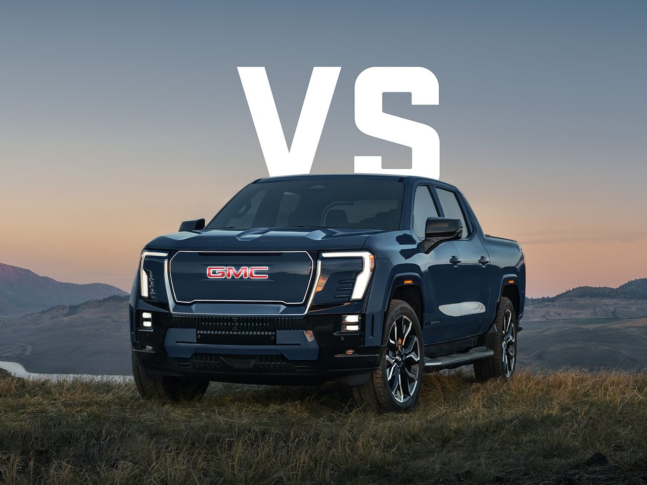 A Low Front View of the 2026 GMC Sierra EV Driving Through a Mountain Road