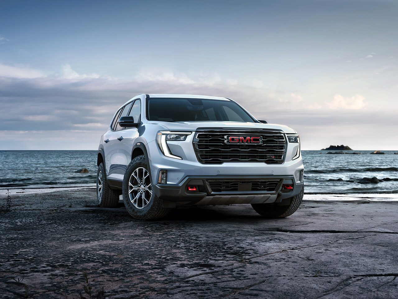 Front Three-Quarters View of a White GMC Acadia Mid-Size SUV Parked on the Beach