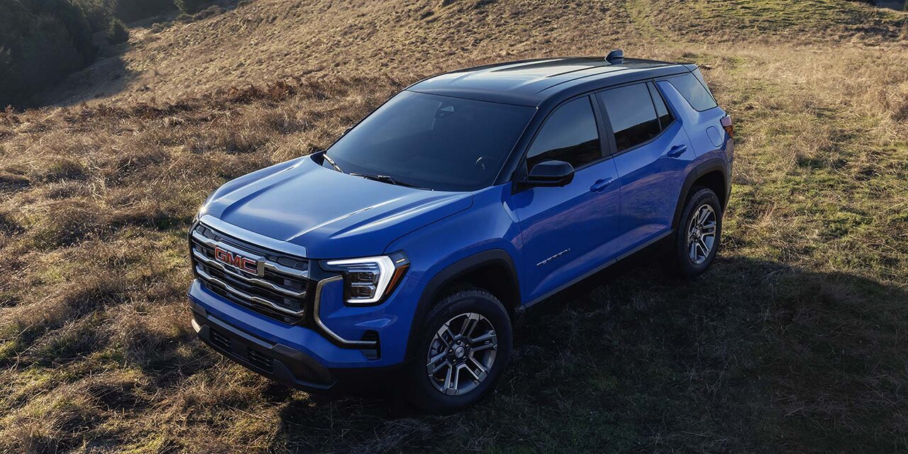 Birds-eye View of a Blue 2026 GMC Terrain Elevation Compact SUV Parked in a Grassy Field