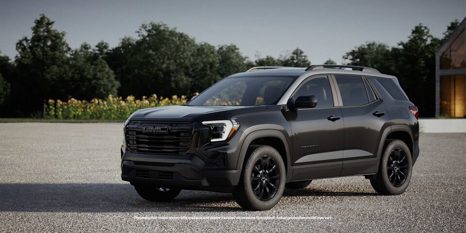 Front Three-Quarters View of the 2026 GMC Terrain Elevation Compact SUV Parked Near a Sunflower Field