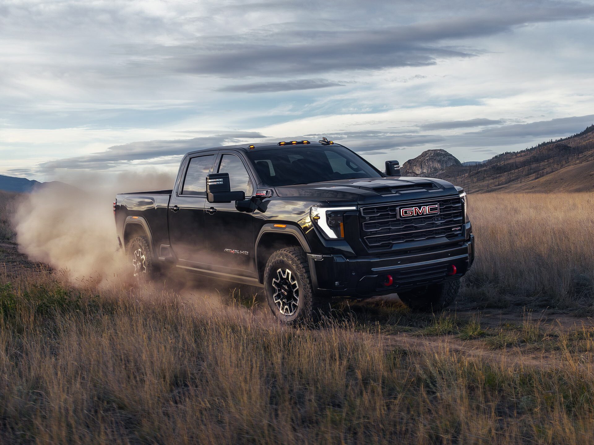 Lineup of 2026 GMC Sierra HD Heavy Duty Trucks Parked Next to Each Other Outlooking the Mountains